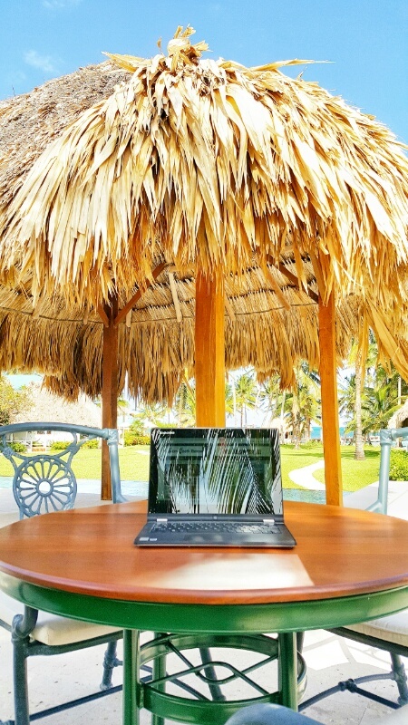 Laptop under a thatched umbrella at Victoria House Belize